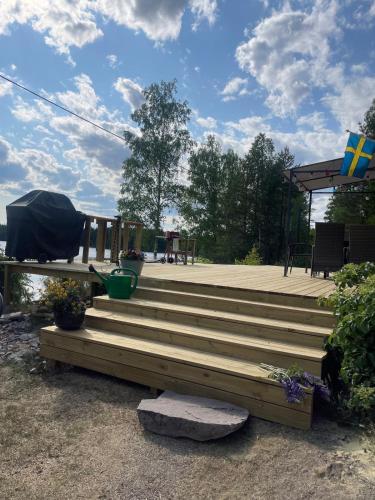 a deck with stairs and a gazebo at Stuga med egen brygga in Fagersta