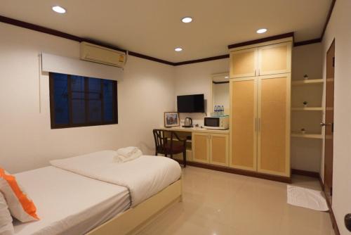 a bedroom with a bed and a desk with a microwave at Sampheng House in Bangkok