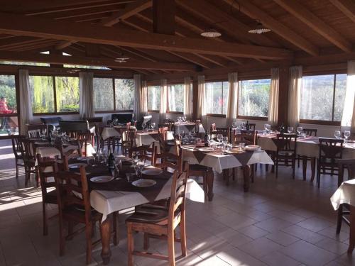 a dining room with tables and chairs and windows at Agriturismo Fara del Falco in Vieste