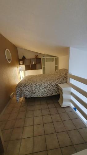 une chambre avec un lit et un sol carrelé dans l'établissement Patios de barcares, au Barcarès