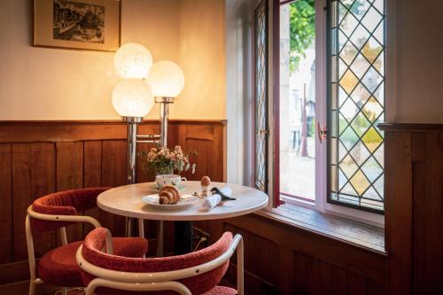 a room with a table and chairs and a window at L'Absinthe Hôtel in Honfleur