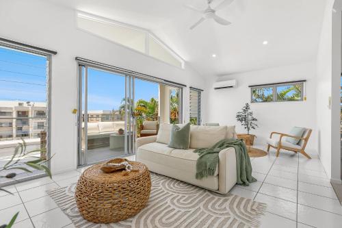 a living room with a couch and a table at Retreat in the Heart of Alex - 3BR sleeps 11, Pool in Alexandra Headland