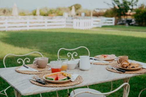 a table with plates of food and drinks on it at Agriturismo Podere L'Agave in San Vincenzo