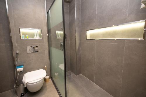 a bathroom with a toilet and a glass shower at nasim aizraq hotel فندق نسيم ازرق in Jeddah