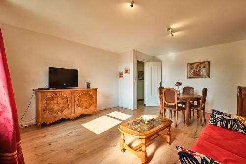 un salon avec une télévision et une table dans l'établissement Gîte du Château St Geoire Véronique, à Saint-Geoire-en-Valdaine