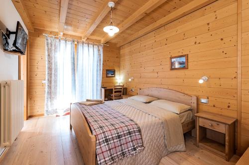 sypialnia z łóżkiem w drewnianym domku w obiekcie Locanda "Al Terrazzo" w mieście Erbezzo
