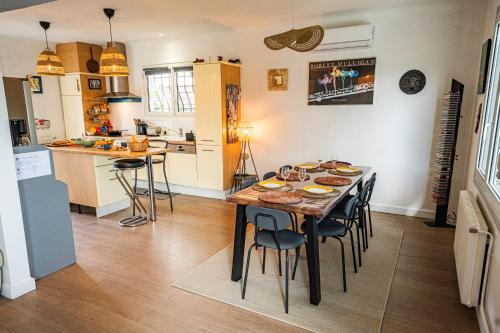 a kitchen and dining room with a table and chairs at Capbreton Surf House in Capbreton