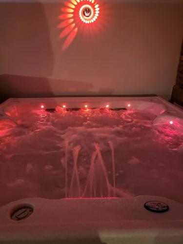 - un bain à remous avec des lumières rouges dans la chambre dans l'établissement Gîte romantique Le Glamour, à Mazé