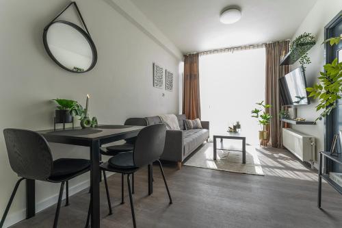 a living room with a table and chairs and a mirror at Modern Stay with Wi-Fi - Tilburg in Tilburg