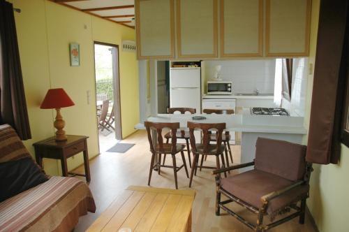 une cuisine et un salon avec une table et des chaises dans l'établissement Relais Du Saussay, à Pertheville-Ners