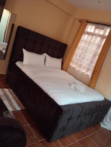 a bed in a small room with a window at Lora's Haven Homes - Kisii Studio2 in Kisii