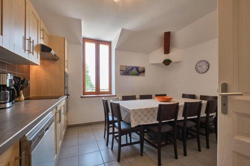 une cuisine avec une table et des chaises dans une cuisine dans l'établissement Grand Gîte du Château de St Geoire, à Saint-Geoire-en-Valdaine