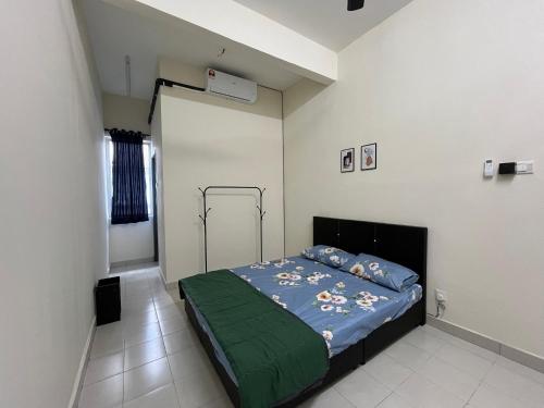 a bedroom with a bed with a green blanket at TemuHomestay in Kamunting