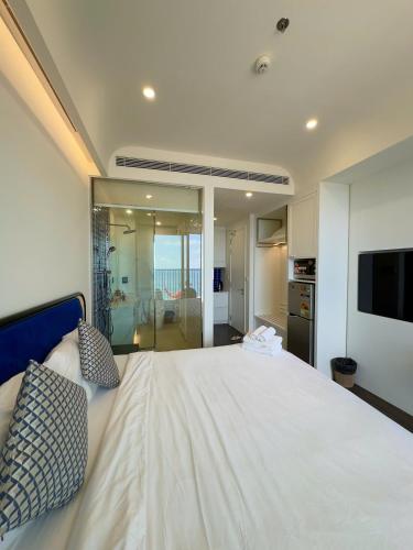 a bedroom with a large white bed and a television at Sunset town Phú Quốc in Phu Quoc