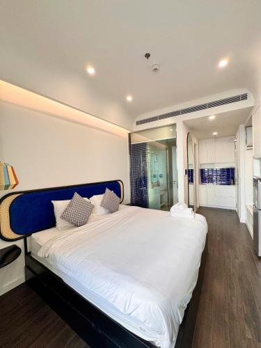 a bedroom with a large white bed with pillows at Sunset town Phú Quốc in Phu Quoc