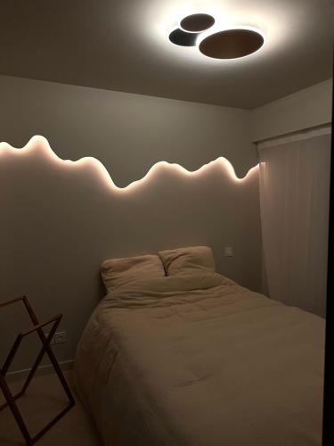 - une chambre avec un lit éclairé au plafond dans l'établissement Escapade cannoise, à Cannes