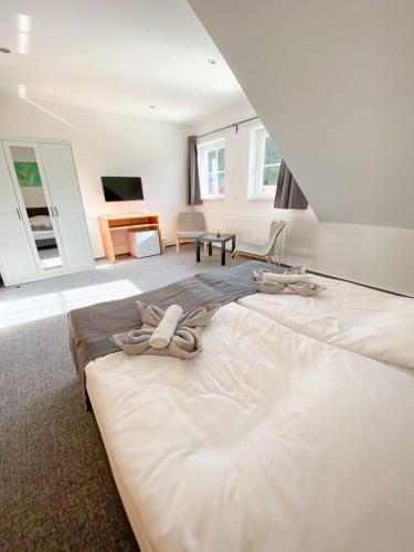 a large white bed in a room with a living room at Roschi's Gästehaus in Gudow
