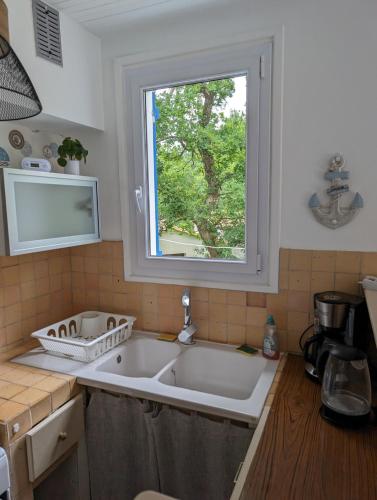 une cuisine avec un grand évier et une fenêtre dans l'établissement MAISON LES MATHES 60 M2, TERRAIN 850 M2, 4 à 6 personnes, aux Mathes