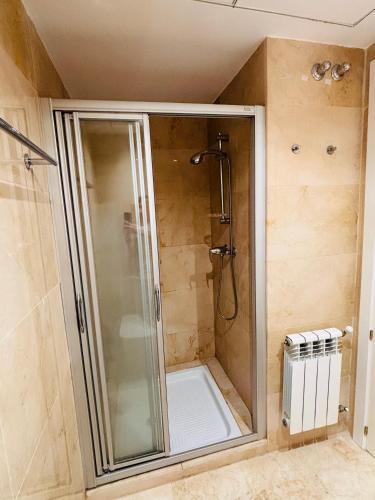 a shower with a glass door in a bathroom at La Cabaña Roda Golf Sol in Roda