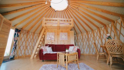 a living room with a red couch in a yurt at Glamping Niebiańska Osada Jurty Dolnośląskie & SPA in Polanica-Zdrój