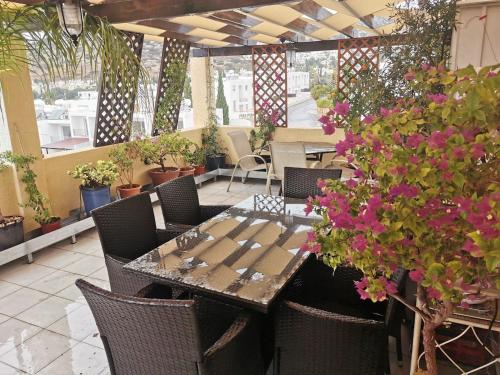 a patio with a table and chairs and flowers at Genista house Peyia in Peyia