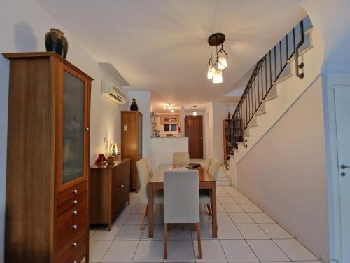 a kitchen and dining room with a table and a staircase at Genista house Peyia in Peyia