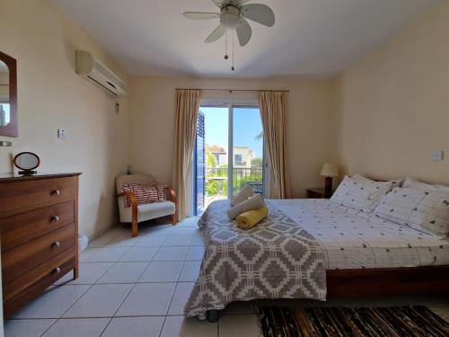 a bedroom with a bed and a window and a dresser at Genista house Peyia in Peyia