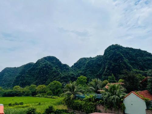 a mountain range with a train in front of it at Tam Coc Hope House in Ninh Binh