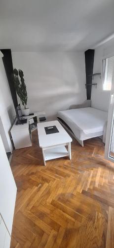 a white room with a bed and a table at Apartman Budva in Budva