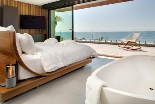 una camera con vasca e un letto con vista di Villa Miramar Frontignan a Frontignan