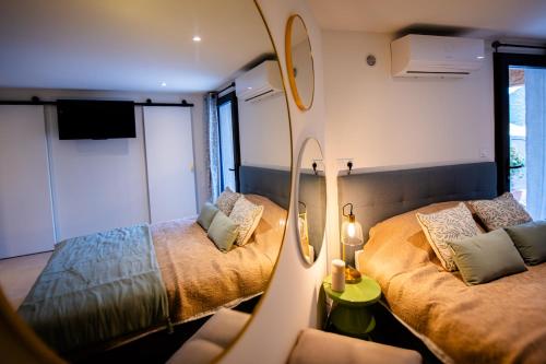 a small room with two beds and a mirror at Conca Paradis Corse à louer entre terre et mer pour 2 personnes in Conca