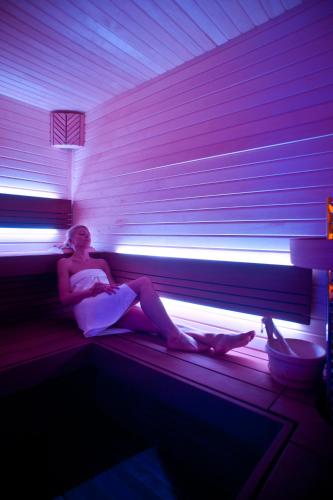 a woman is sitting on a couch in a room at Hotel Garnì Cristallo in Ponte di Legno