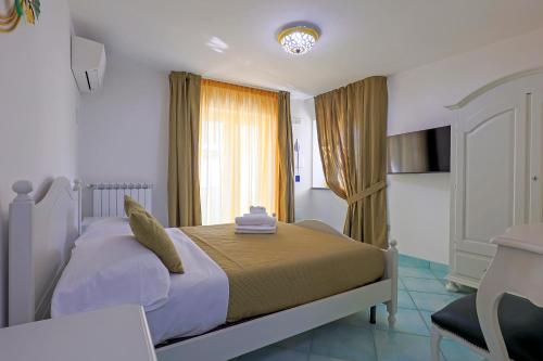 a bedroom with a large bed with a window at Villa Le Porpore in Furore