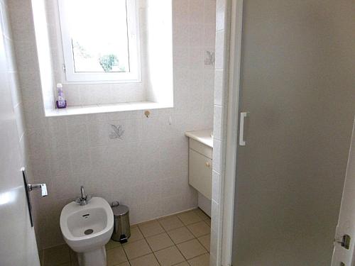 une salle de bain blanche avec toilettes et fenêtre dans l'établissement Maison 4 pièces 6 personnes proche de la mer - HEOL, à Sarzeau