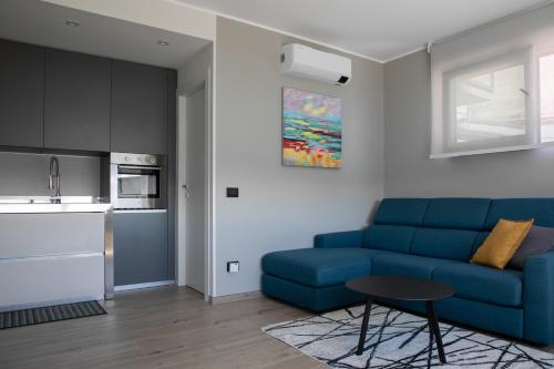 a living room with a blue couch and a table at Casa del lago in Oggebbio