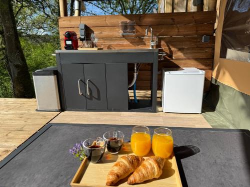 a tray of croissants and two glasses of orange juice at EcoLodge Libellule romantique pour amoureux in Cazats