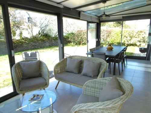 - une véranda avec des chaises et une table dans l'établissement Maison 5 pièces 8 personnes avec jardin clos à 700 m de la plage - LOAVEN, à Sarzeau