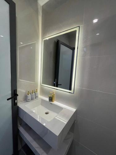 a white bathroom with a sink and a mirror at Adora Homestay Hue in Hue