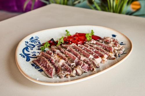 a plate of food with meat on a table at Ibis Styles Madrid Airport Valdebebas in Madrid