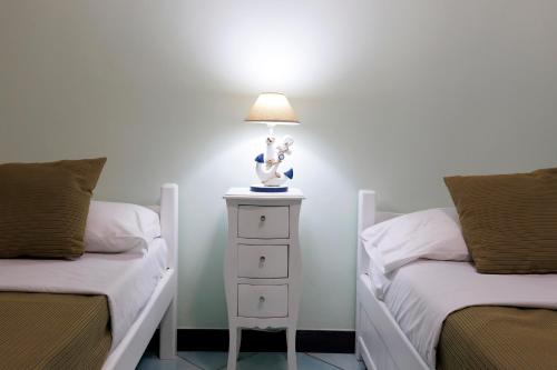 a bedroom with two beds and a lamp on a night stand at Villa Le Porpore in Furore