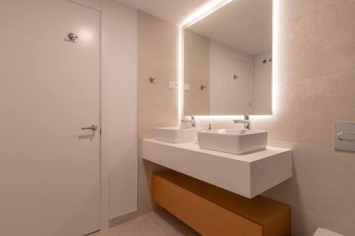 a bathroom with two sinks and a mirror at EL Eden casa 71 in Málaga