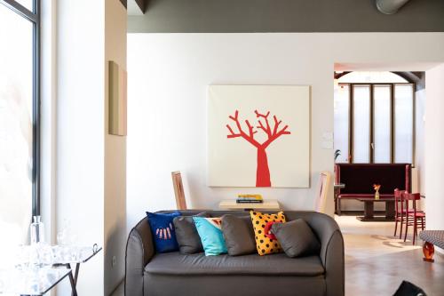 a living room with a couch with a tree picture on the wall at Savona 18 Suites in Milan