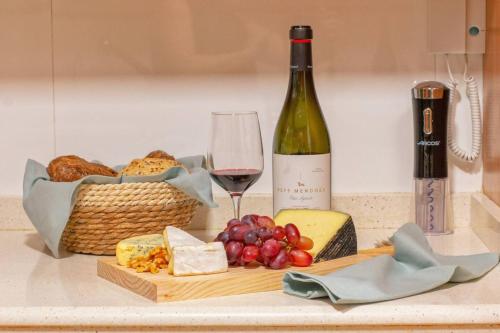 a bottle of wine and a basket of bread and cheese at Apartamento Sant Pere II in Benissa