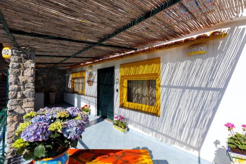 a porch of a house with flowers on it at Villa Le Porpore in Furore