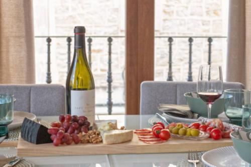 a table with a bottle of wine and a plate of food at Apartamento Sant Pere II in Benissa