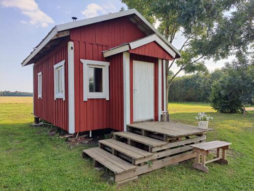 a red tiny house with a ramp and a bench at Nigula Country Home in Leie