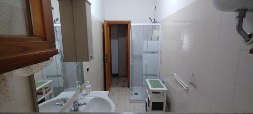 a white bathroom with a sink and a shower at Casa Marilù in Alghero