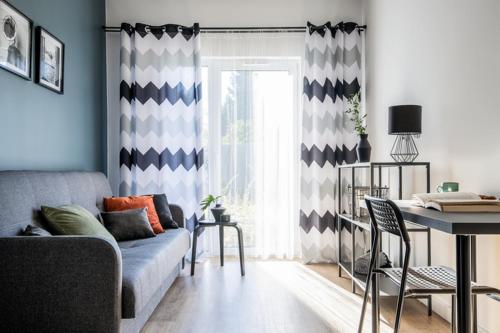 a living room with a couch and a window at ADLER Studio in Łódź