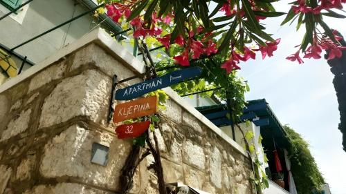 プナトにあるApartman Mocicの花が飾られた建物の上の青い道路標識