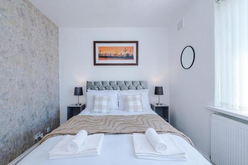 a white bedroom with a large bed with white pillows at Stylish 3 bed house sleeps 5 free parking in Dudley Hill